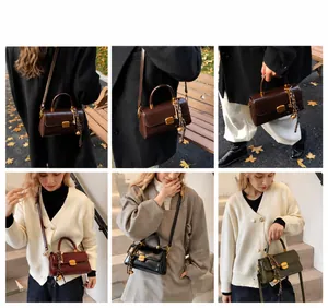 Detalle de bolso vintage con hebilla cuadrada dorada y colgante de cadena metálica
