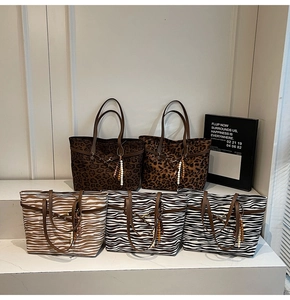 Detail of five large tote bags with leopard and zebra animal prints and beaded handles