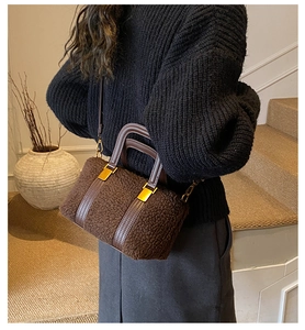 Brown faux shearling baguette bag with leather straps worn by model on stairs