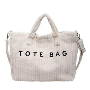 Off-white corduroy tote bag with black embroidered text and adjustable shoulder strap