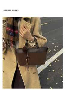 Detail of suede leopard tote bag with fur ball tassel charm and vintage wood bead accent