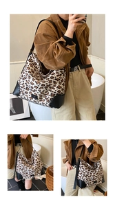 Detail of leopard print tote bag with black leather corner protectors and stitching