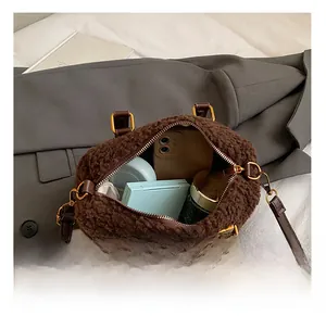 Internal view of brown faux shearling bag showing storage space for phone and makeup
