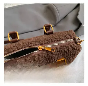 Close-up of golden hardware and leather strap on brown fuzzy lambskin handbag