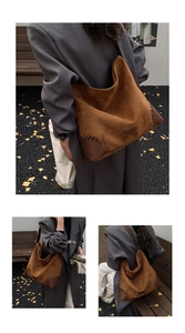 Detail of suede stitching and leather corner reinforcement on a brown hobo shoulder bag