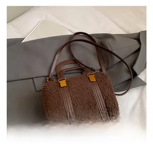 Macro detail of brown plush teddy fabric and golden metal hardware on a boston handbag