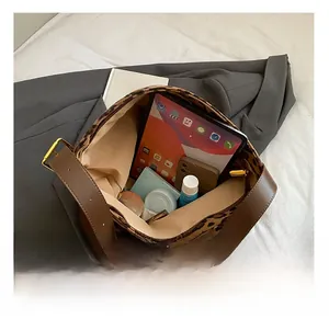 Interior view showing large capacity of leopard print shoulder bag with iPad and cosmetics