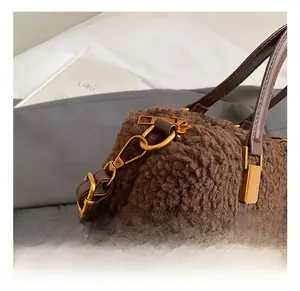 Close-up of golden metal hooks on brown teddy fur handbag with premium leather strap