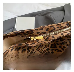 Close-up of leopard print tote bag with premium metal zipper and brown leather strap