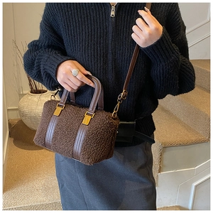 Detail of coffee brown plush Boston bag featuring lamb wool texture and leather handles