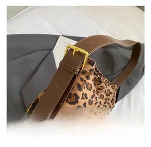 Detail of adjustable brown leather shoulder strap with leopard print suede fabric