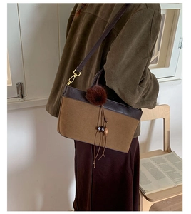 Detail of vintage leopard style crossbody bag with leather patchwork and tassel charm