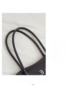 Détail de bandoulières en cuir marron foncé avec boucles métalliques et coutures soignées