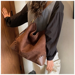 Detail of vintage suede hobo bag with thick hand-stitched seams and smooth leather base