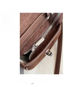 Detail of silver metal zipper and brown suede texture on a vintage saddle bag