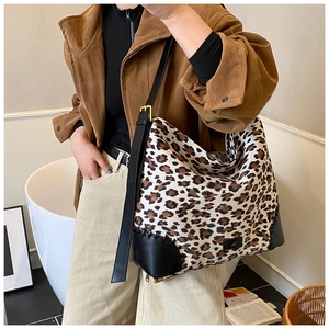 Close-up of leopard print hobo bag with black leather base and adjustable strap