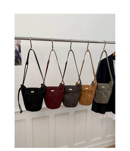 Serie di borse a secchiello vintage in pelle scamosciata in cinque colori su un rack
