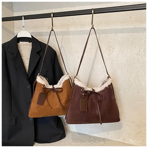 Detail of suede shoulder bags with faux shearling lining and decorative bow accents