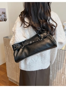 Vue détaillée du sac sous le bras en cuir noir avec boucle en métal et sangle