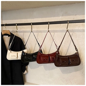Close-up of stylish patent leather hobo bags with decorative bows in four different colors