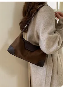 Dettaglio della borsa hobo vintage con texture a contrasto in camoscio e pelle marrone