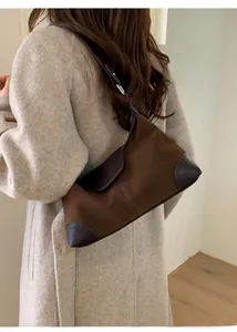 Vista dettagliata della borsa sottobraccio marrone con texture in pelle e design compatto