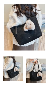 Detail of black suede tote bag with white plush rabbit charm and fashion logo print