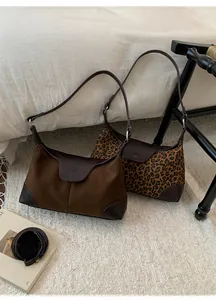Dettaglio di borse a tracolla vintage in camoscio marrone e stampa leopardata con cinturini