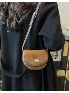 Brown frosted saddle bag shown from back view on model wearing a black winter coat