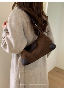 Dettaglio della borsa sottobraccio marrone vintage con cuciture in pelle e fibbia metallica