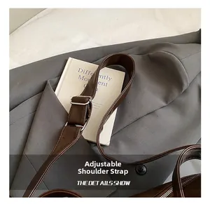 Detail eines verstellbaren dunkelbraunen Ledergurts mit silberner Schnalle an Tasche