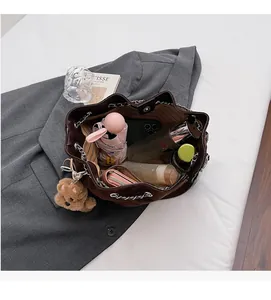 Interior view of brown bucket bag showing large capacity and yellow striped lining