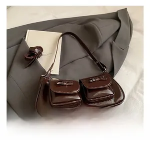 Detail of dark brown patent leather underarm bag featuring bow-knot pockets and retro style