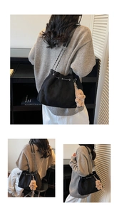 Detail of suede bucket bag featuring silver chain strap and a cute plush bear pendant