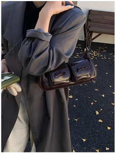 Detail of dark brown glossy patent leather shoulder bag with chic bow accents