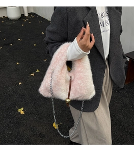 Detailed view of pink and white gradient faux fur bucket bag with golden metal ball