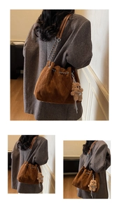 Detail of brown quilted suede bucket bag with chain strap and teddy bear charm