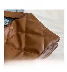 Detail shot of brown quilted rhombus pattern stitching on matte faux leather shoulder bag