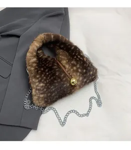 Detail view of plush faux fur handbag with leopard spots and gold metallic hardware