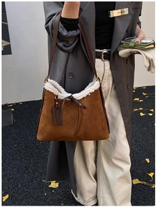 Dettaglio borsa a spalla in pelle scamosciata marrone con bordo in shearling bianco e fiocco
