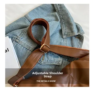 Close-up of adjustable metal buckle strap on brown quilted leather tote bag