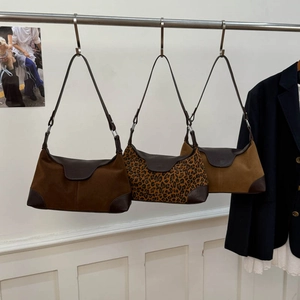 Dettaglio di borse sottobraccio in pelle scamosciata retrò in marrone e maculato