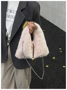 Vue détaillée d'un sac à main élégant en fausse fourrure rose et blanche avec chaîne