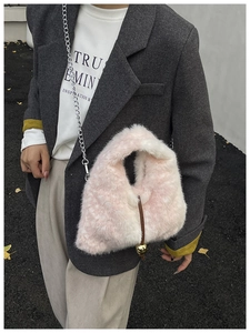 Close-up of pink and white faux fur bag with silver chain and gold metal ball charm