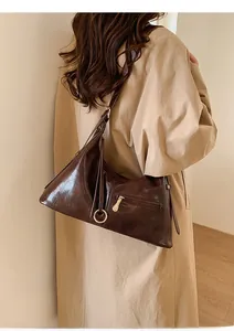 Détail du sac cabas en cuir marron foncé avec texture lisse et boucle en anneau métallique