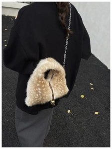Detail of plush bucket bag featuring deer print texture and golden chain strap for women