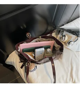 Detailed interior of a deep red tote bag showing large capacity for laptops and folders