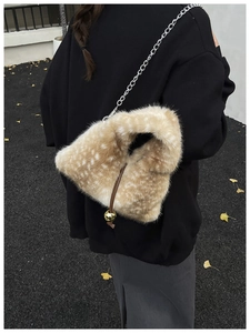 Detailed view of plush bucket bag with deer print faux fur and silver chain strap