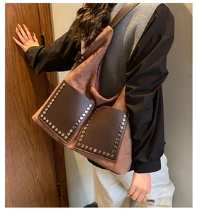 Detail der Vintage Wildleder-Einkaufstasche mit Nieten und braunen Ledertaschen