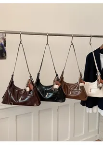 Détails de sacs demi-lune en cuir brillant avec breloques cœur et pompon en quatre coloris